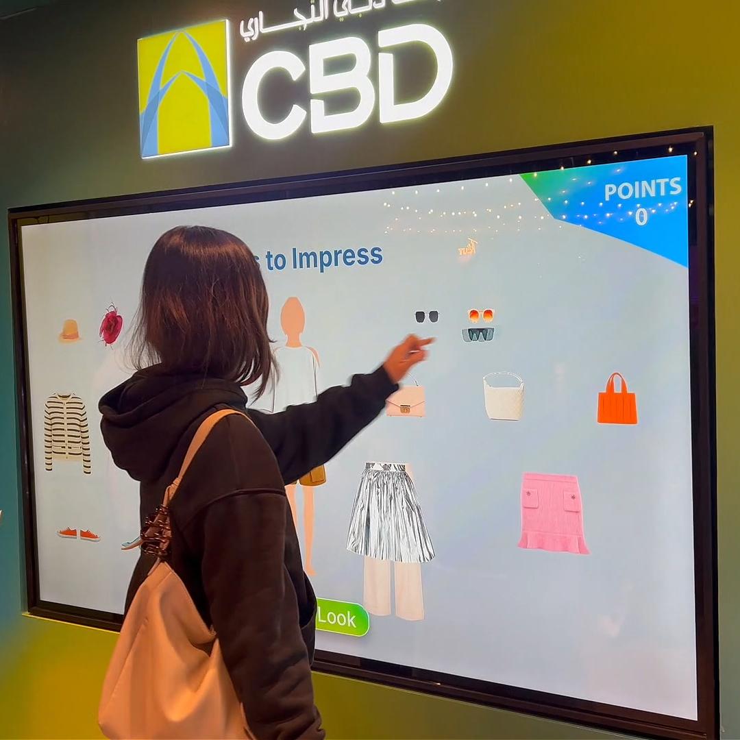 People playing a multi-level interactive financial literacy game at a brand activation event in Dubai, learning how to save and invest money.